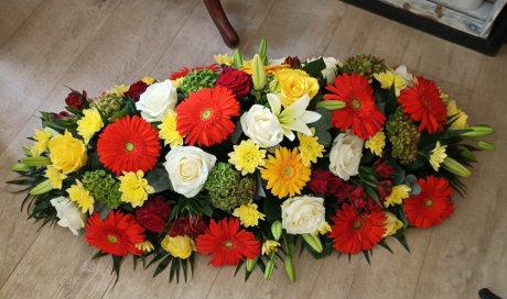 raquette pour deuil couleurs chaudes par votre fleuriste Dites le avec des fleurs à Saint Aubin D'Aubigné