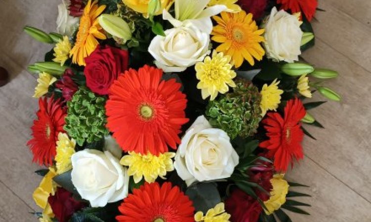raquette pour deuil couleurs chaudes par votre fleuriste Dites le avec des fleurs à Saint Aubin D'Aubigné